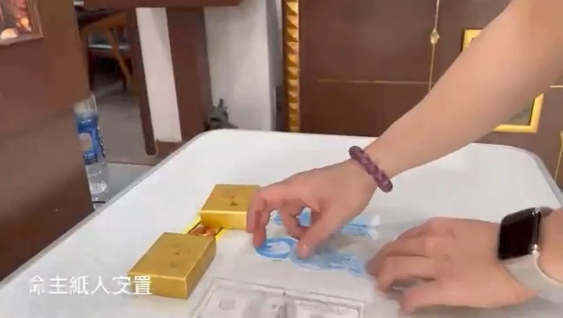 梁先生本人参与命主纸人与仪式材料安置的手部画面